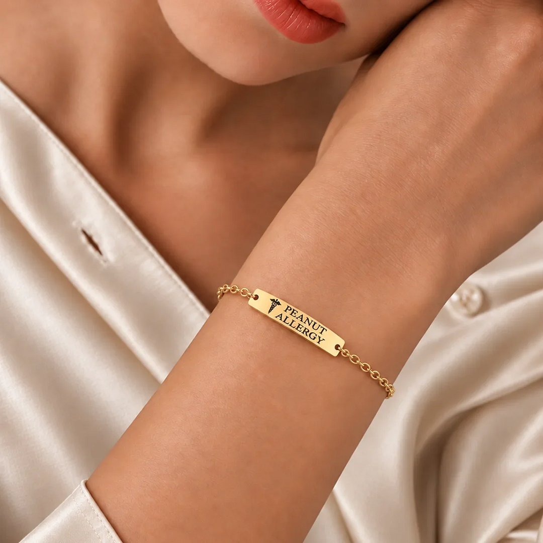 Woman wearing a gold medical alert bar bracelet engraved PEANUT ALLERGY with a medical symbol