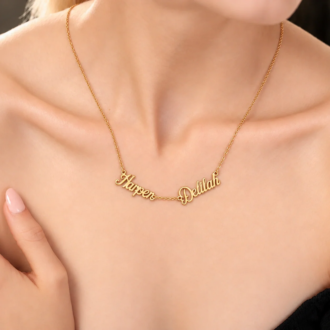 Woman wearing a gold multiple name necklace reading Harper and Delilah in connected script lettering