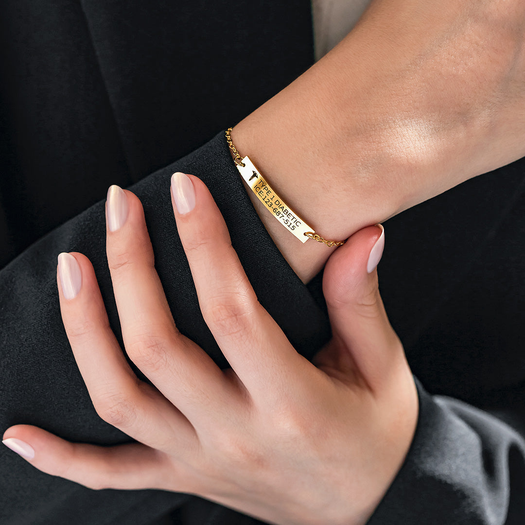 Medical alert bracelet worn on wrist, engraved with condition and emergency contact