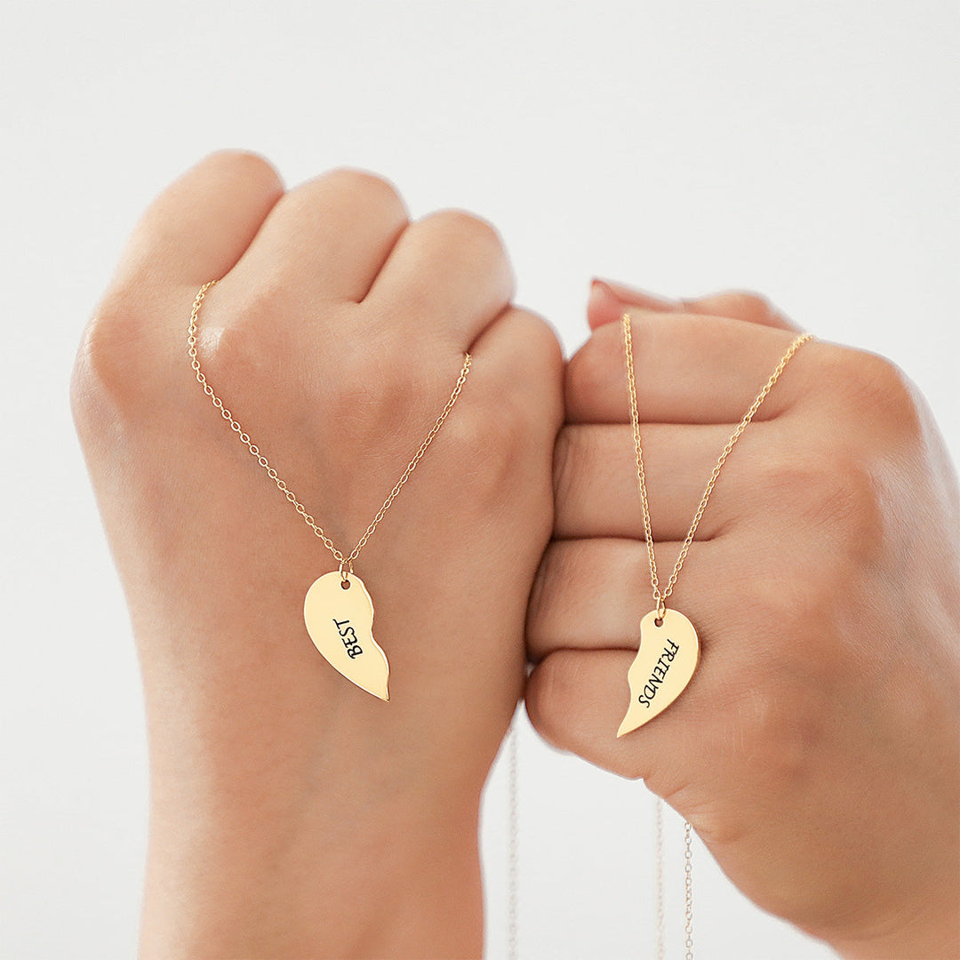 Two friends wearing matching halves of the VIVO Minimalist Personalized Split Heart Necklace Set in 14K Gold Vermeil, a meaningful best friend necklace set.