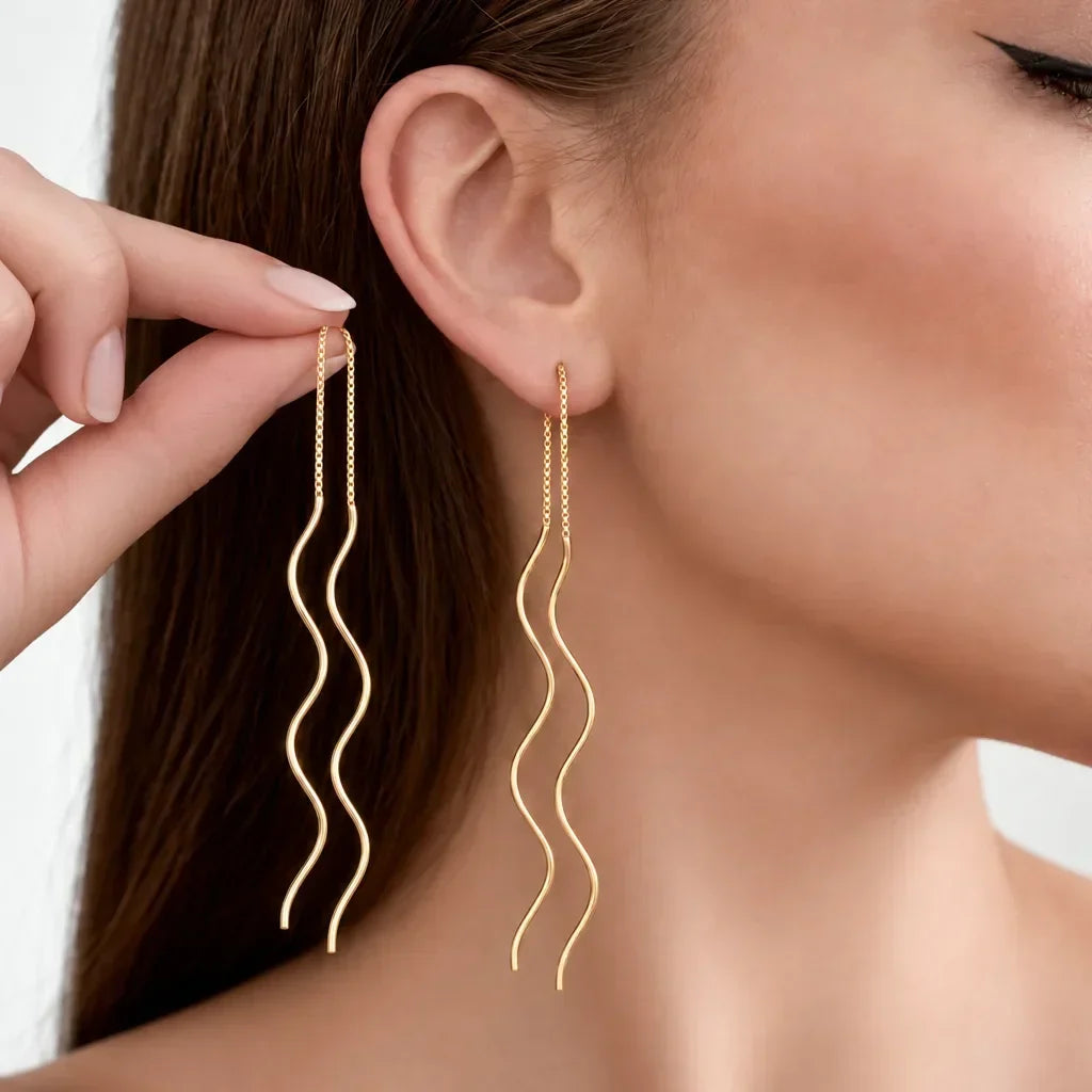 Spiral threader earrings in gold vermeil worn in the ear, showing the waved drop