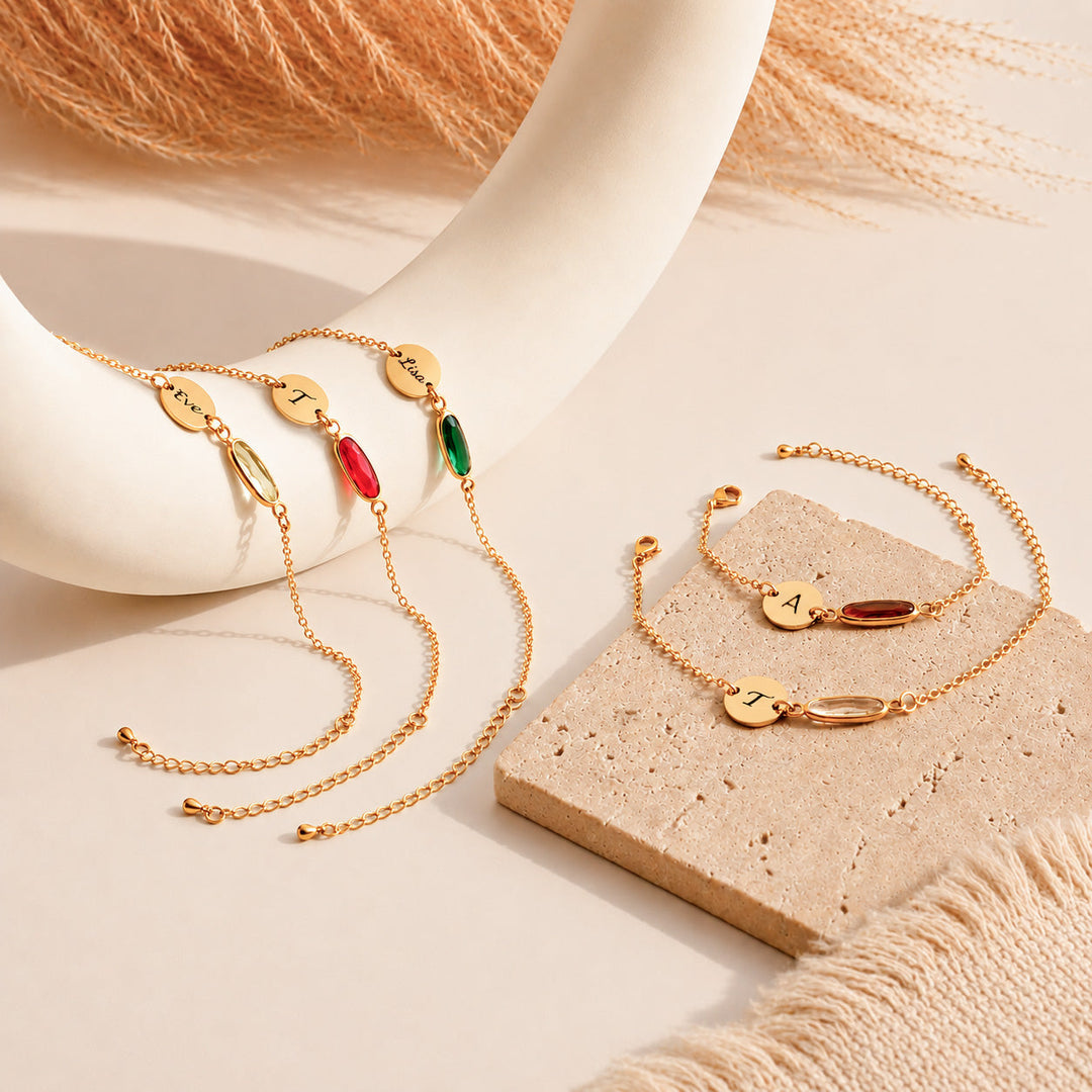 personalized gold birthstone initial bracelets with engraved name discs on neutral background