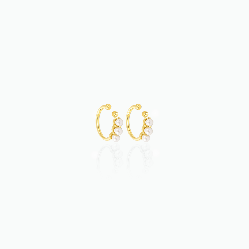 Gold hoop earrings with pearls on a white background
