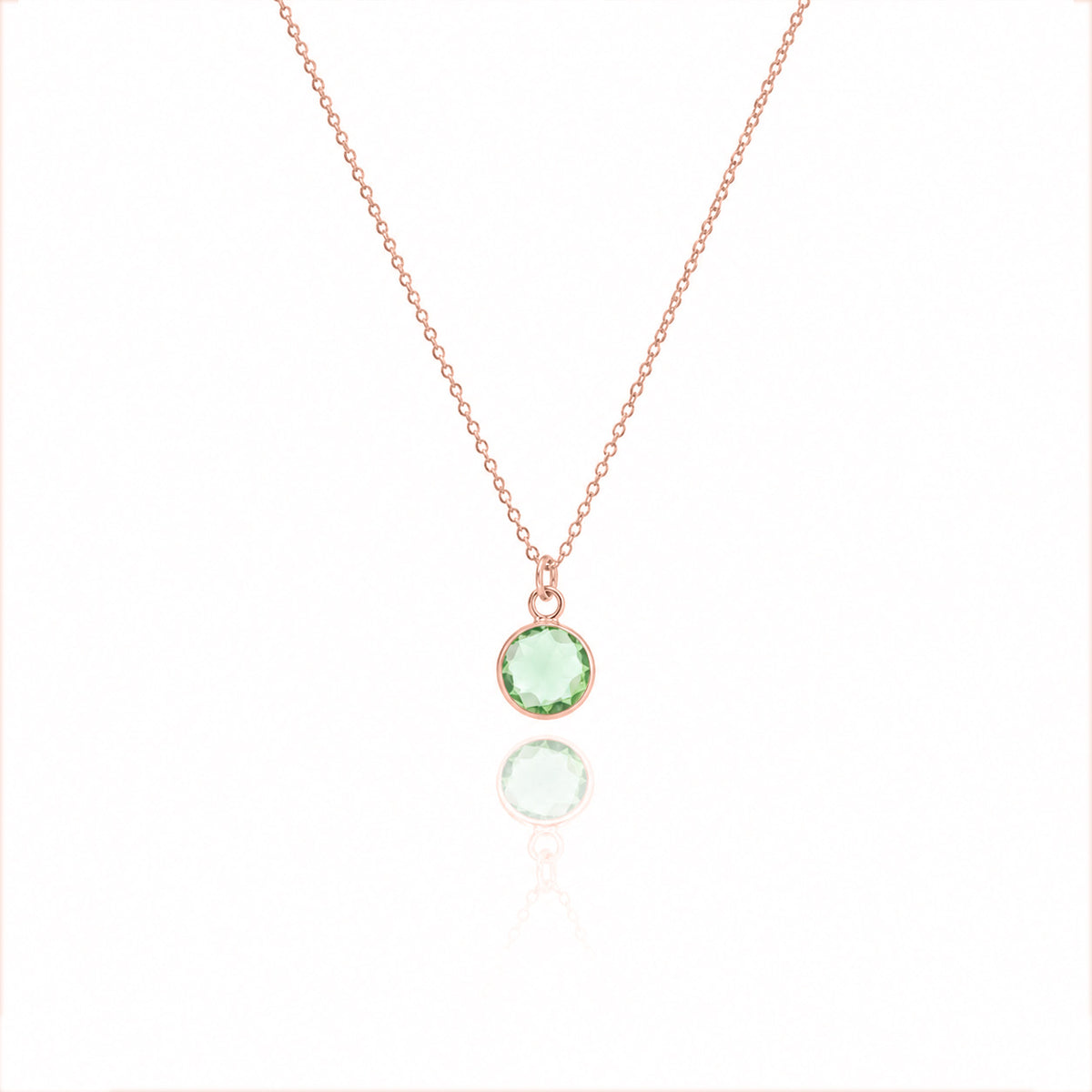 Rose-gold-tone necklace with a light green faceted round pendant on a white background