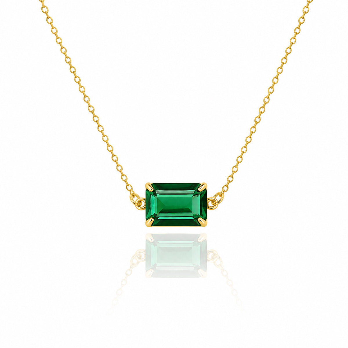 Gold-tone necklace with a rectangular green faceted pendant on a white background
