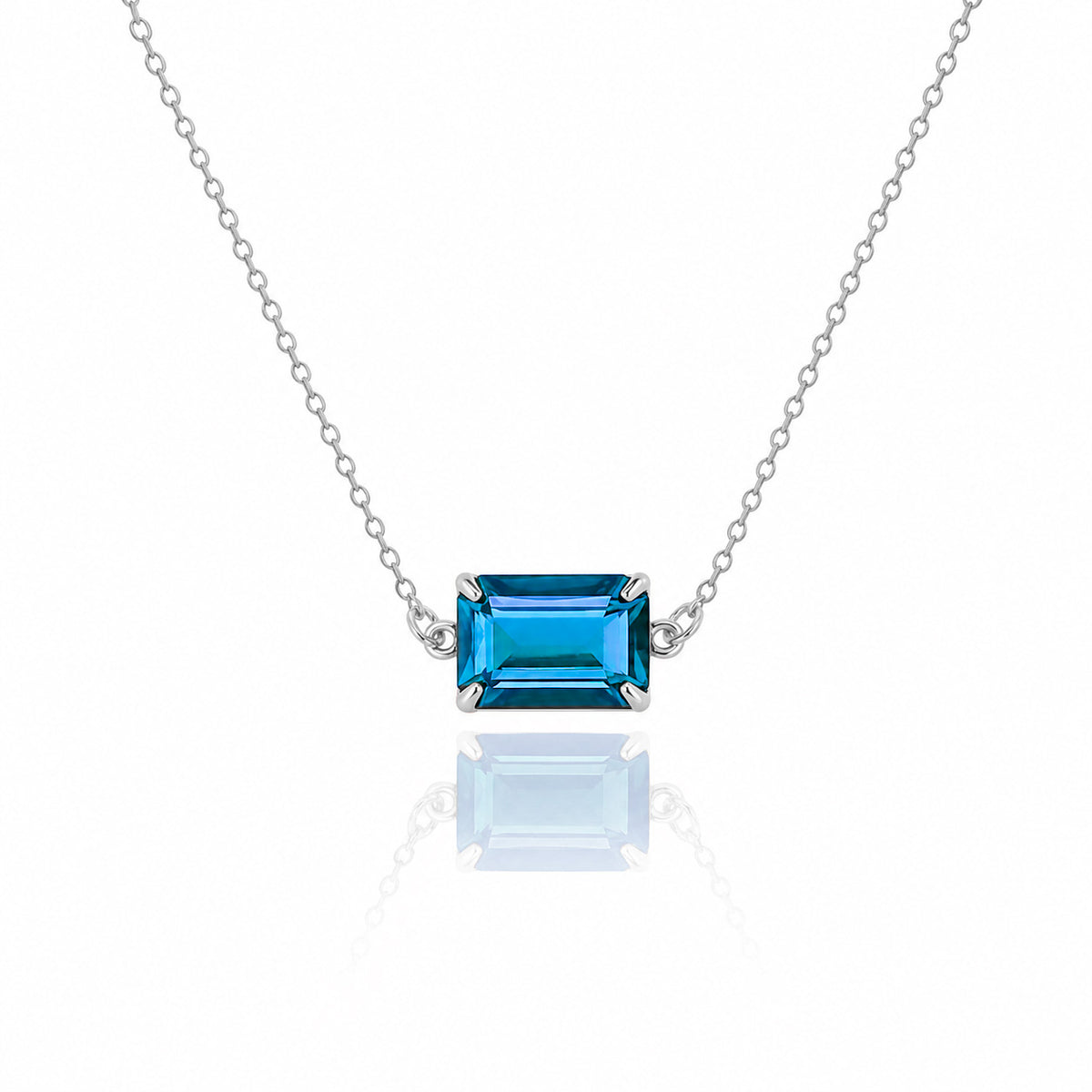 Silver-tone necklace with a rectangular blue faceted pendant on a white background