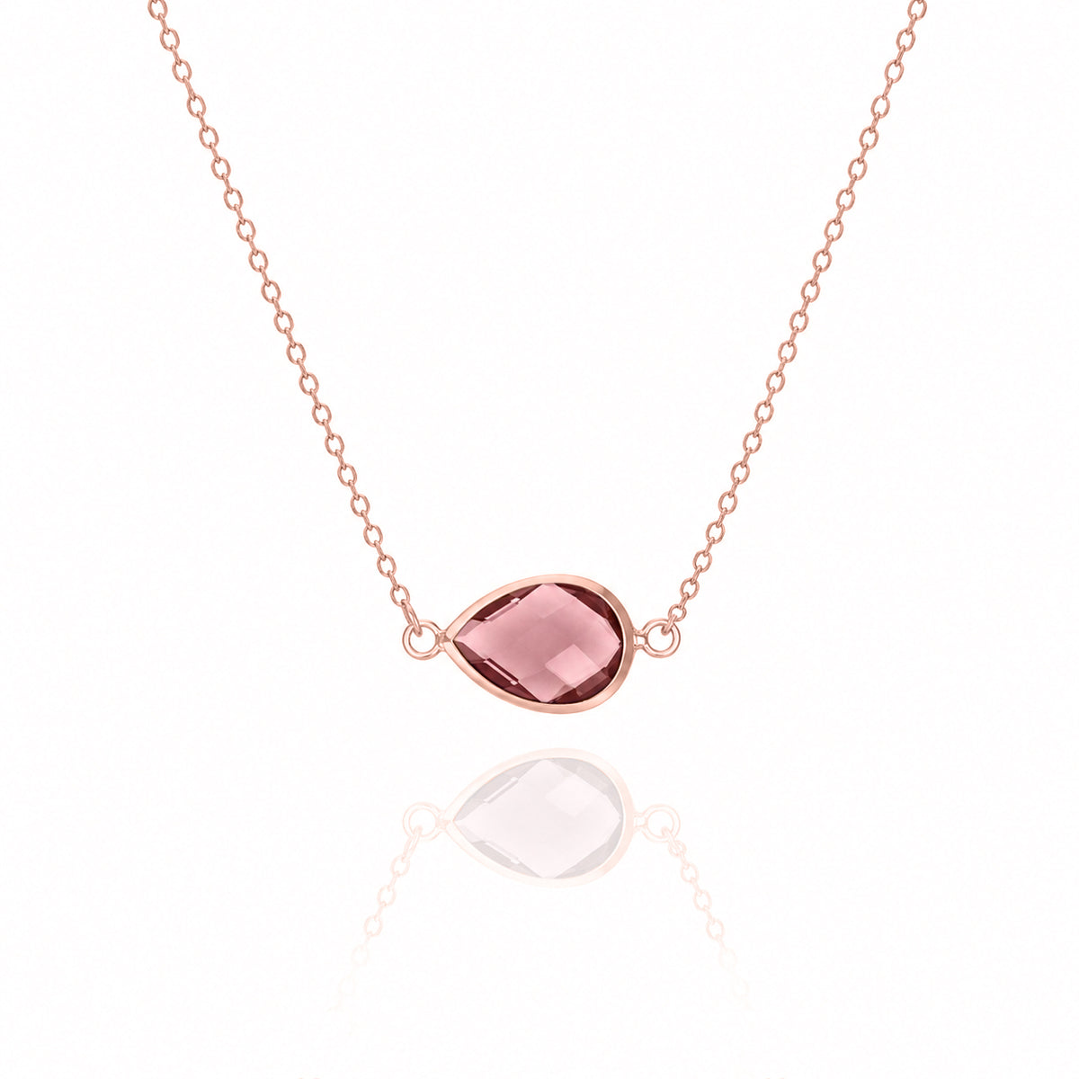 Rose-gold-tone necklace with a pink faceted teardrop pendant on a white background