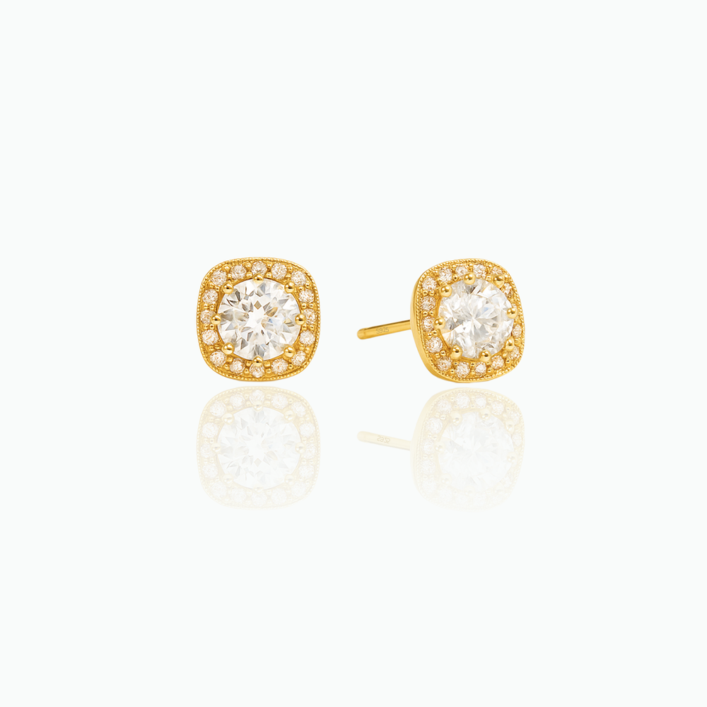 Gold earrings with clear gemstones on a white background