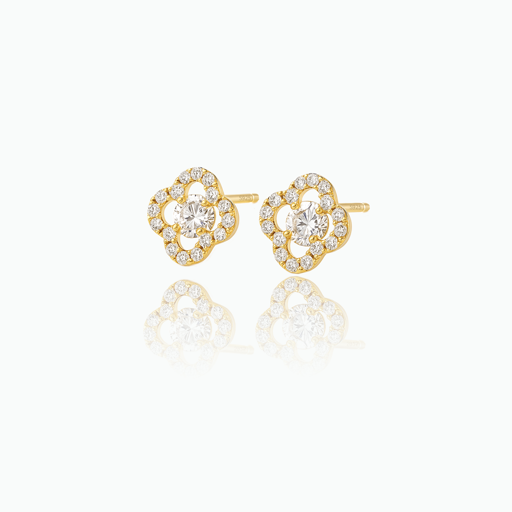 Gold earrings with diamond accents on a white background