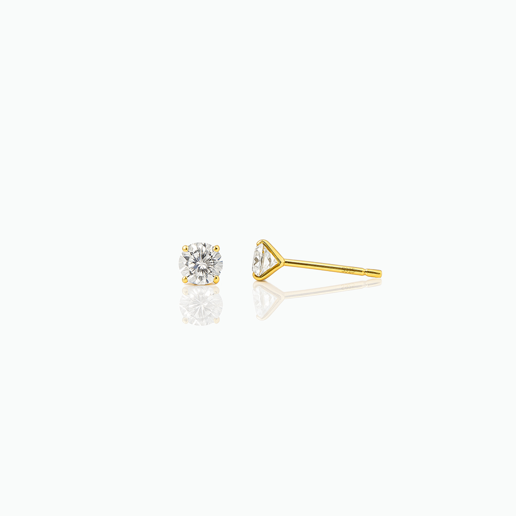 Gold stud earring with clear gemstone on a white background
