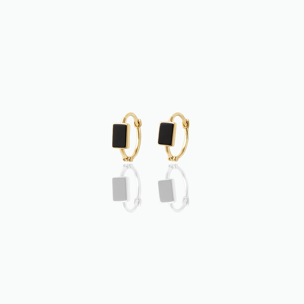 Gold hoop earrings with black square charms on a white background