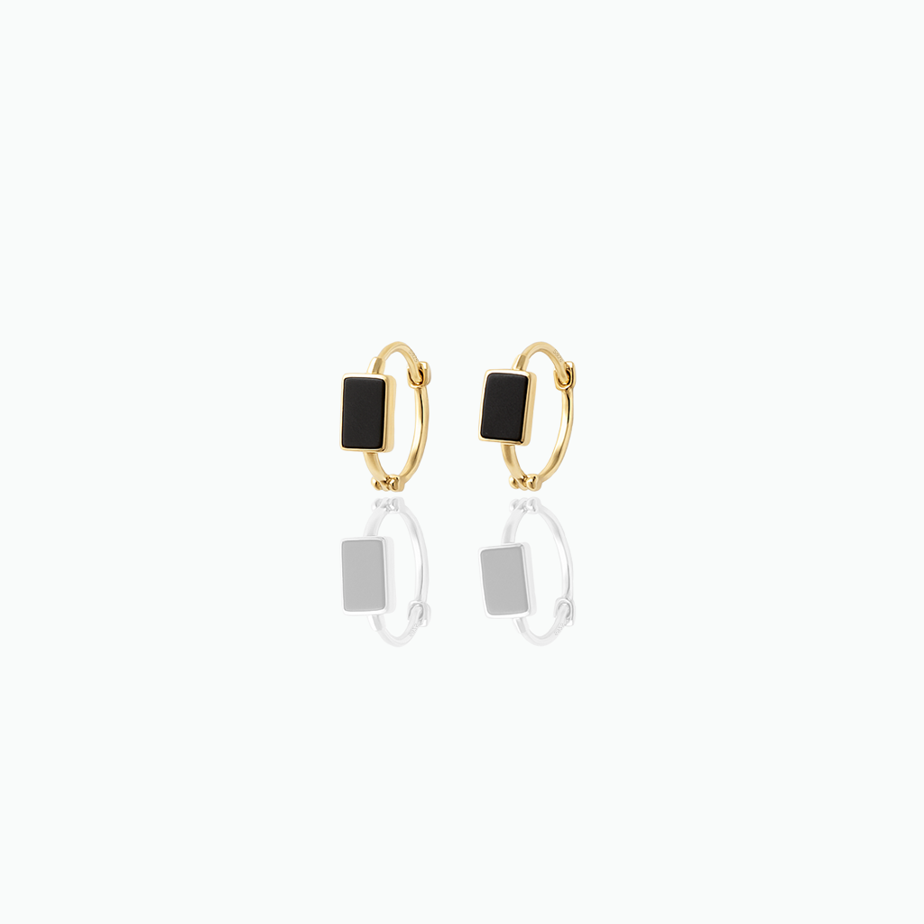 Gold hoop earrings with black square charms on a white background