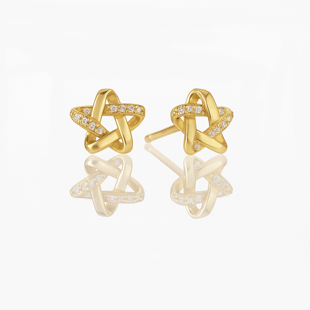 A pair of dainty sterling silver star earrings with a gold vermeil finish and small sparkling stones embedded in the design.