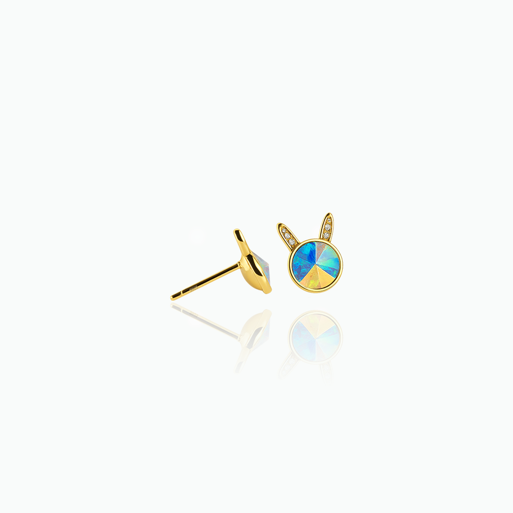 Gold earrings with a colorful gemstone on a white background