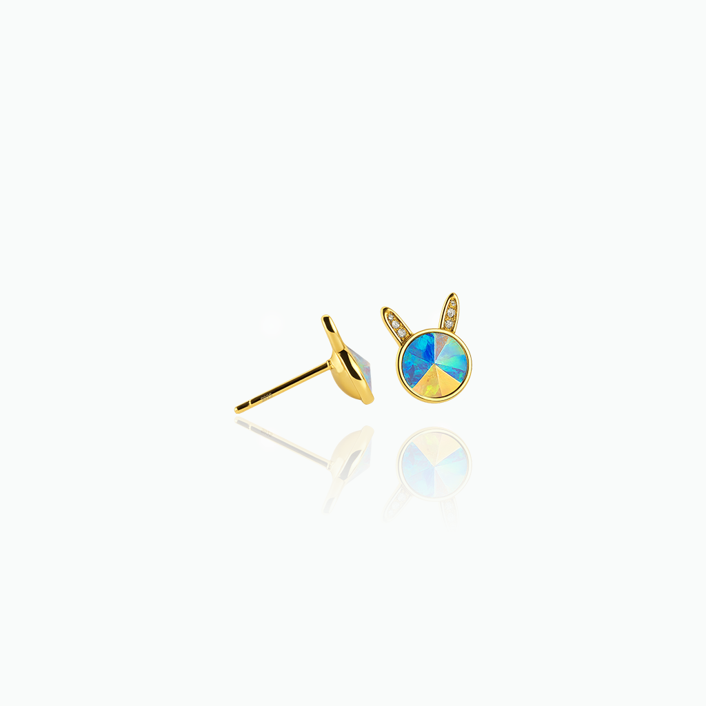 Gold earrings with a colorful gemstone on a white background