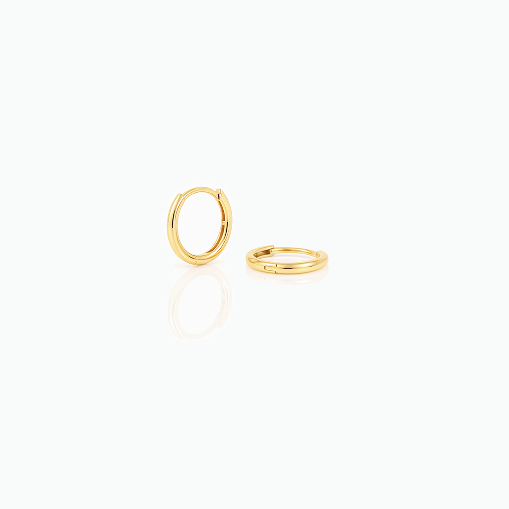 Two gold hoop earrings on a white background