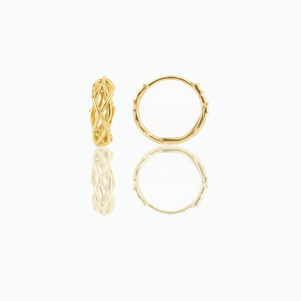 A pair of minimalist huggie hoop earrings made of gold, displayed against a white background.