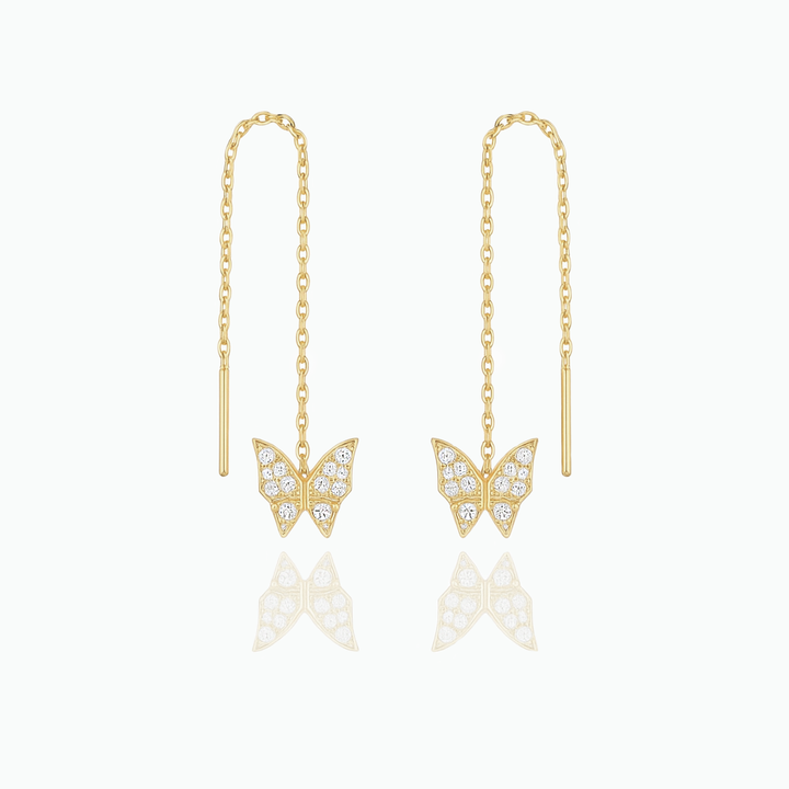 Gold butterfly earrings with chain drops on a white background