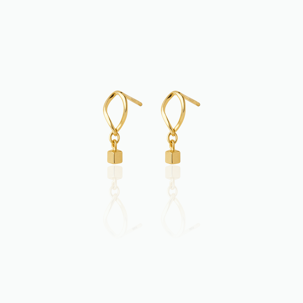 Gold earrings with cube-shaped drops on a white background