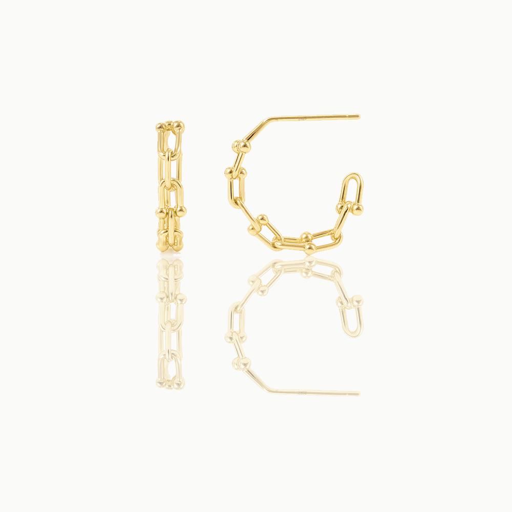 A pair of delicate huggie earrings made of gold vermeil, displayed against a white background.