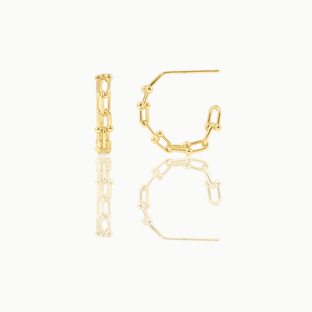A pair of delicate huggie earrings made of gold vermeil, displayed against a white background.