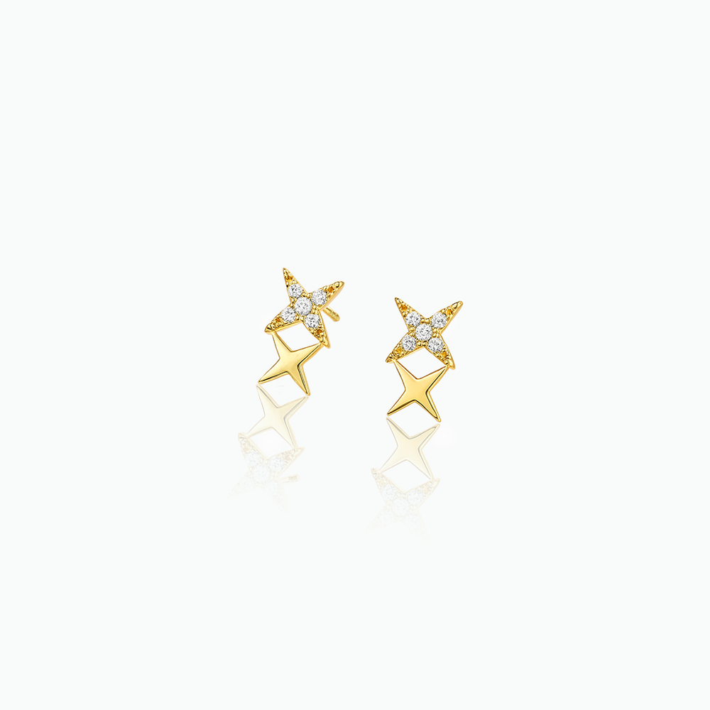 Gold star-shaped earrings with small diamonds on a white background