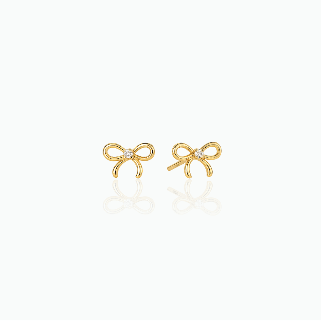 Gold bow-shaped earrings with clear gemstones on a white background