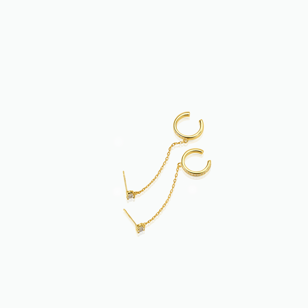 Gold earring with a chain on a white background