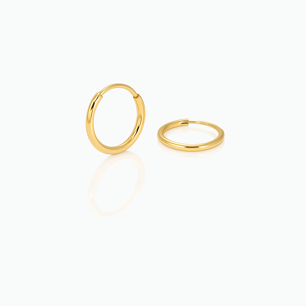 Two gold hoop earrings on a white background
