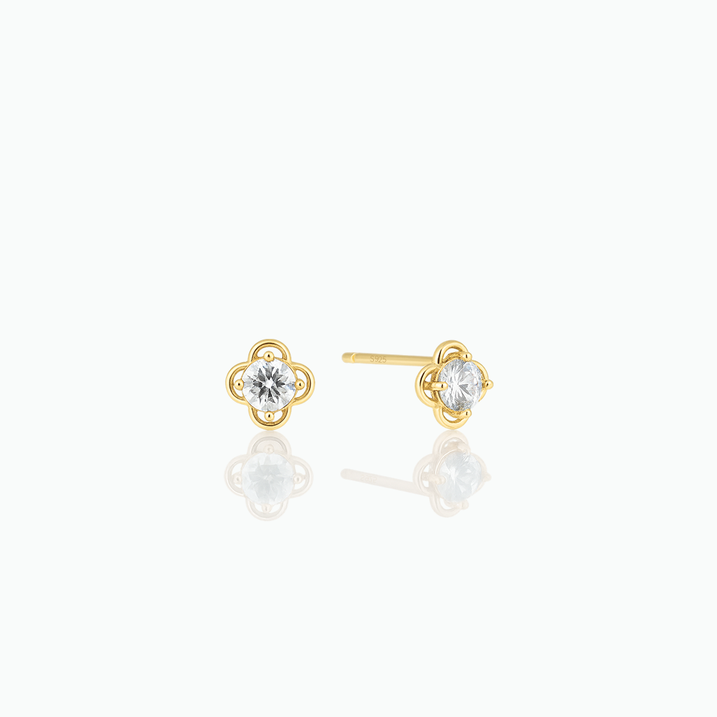 Gold earrings with clear gemstones on a white background