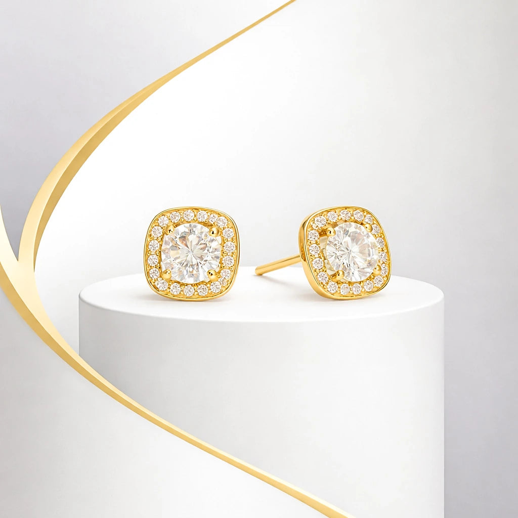 Gold earrings with clear gemstones on a white and gold stand