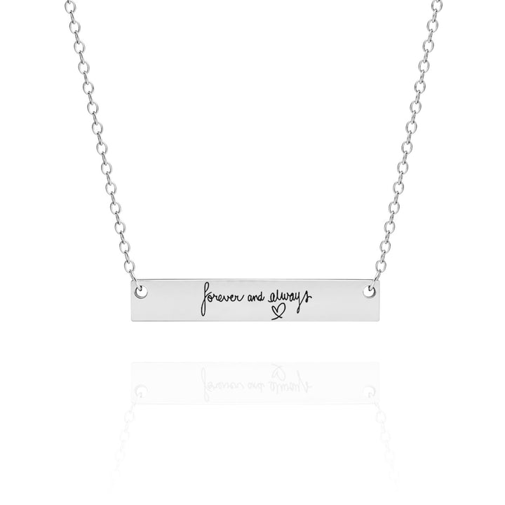 Silver necklace with 'forever and always' bar pendant on a white background