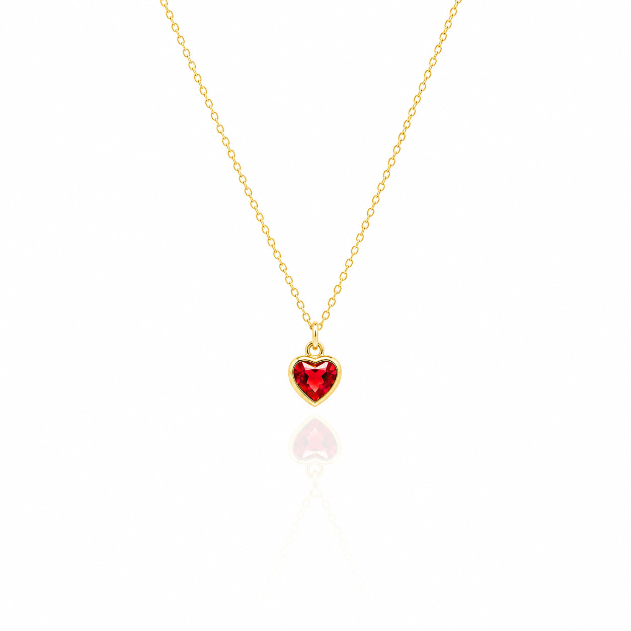 Gold necklace with a red heart-shaped pendant on a white background