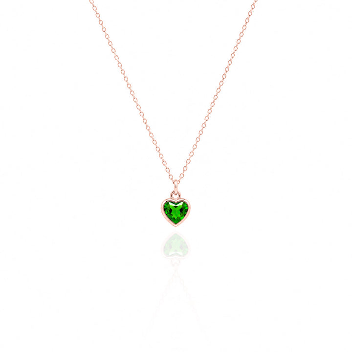 Heart-shaped green gemstone pendant on a rose gold chain against a white background