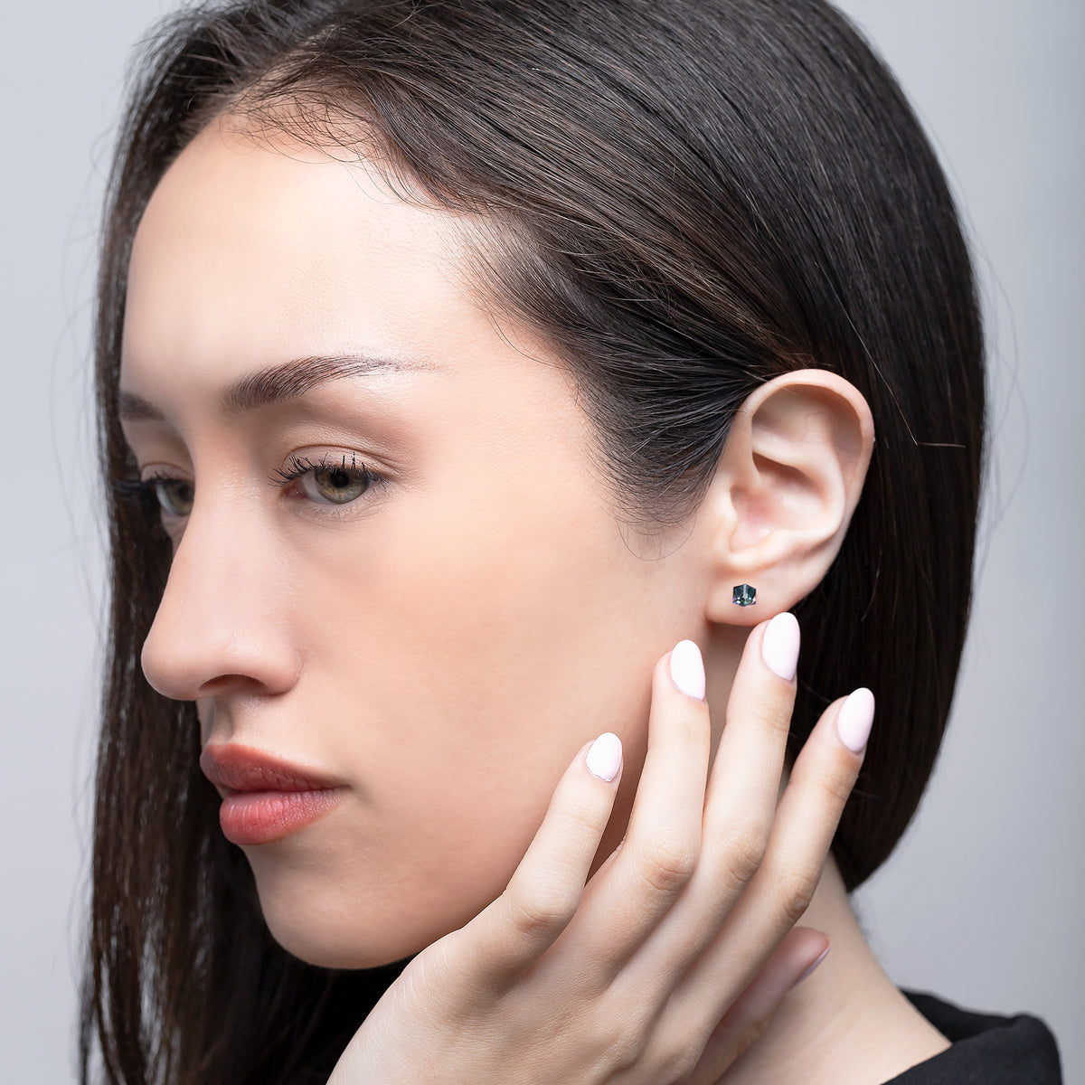 Close-up of a woman wearing an earring with a neutral background