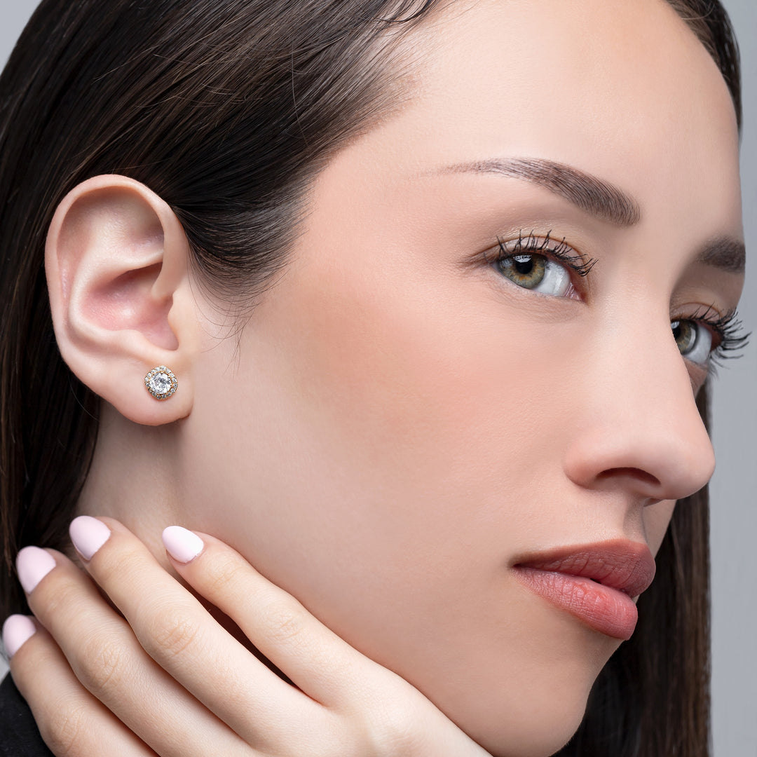 Close-up of a woman wearing a diamond earring with a neutral background