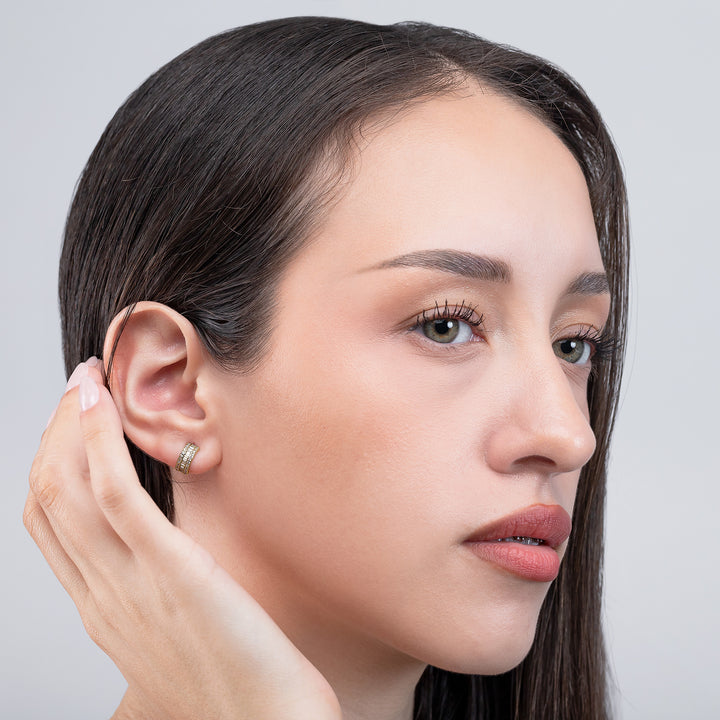 Close-up of a woman wearing an earring with a plain background