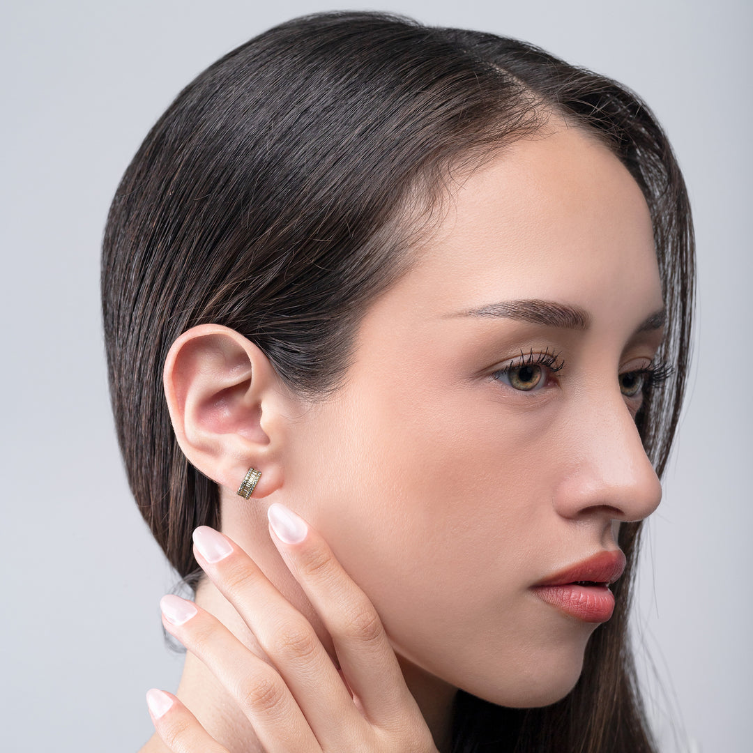 Close-up of a woman wearing an earring with a plain background