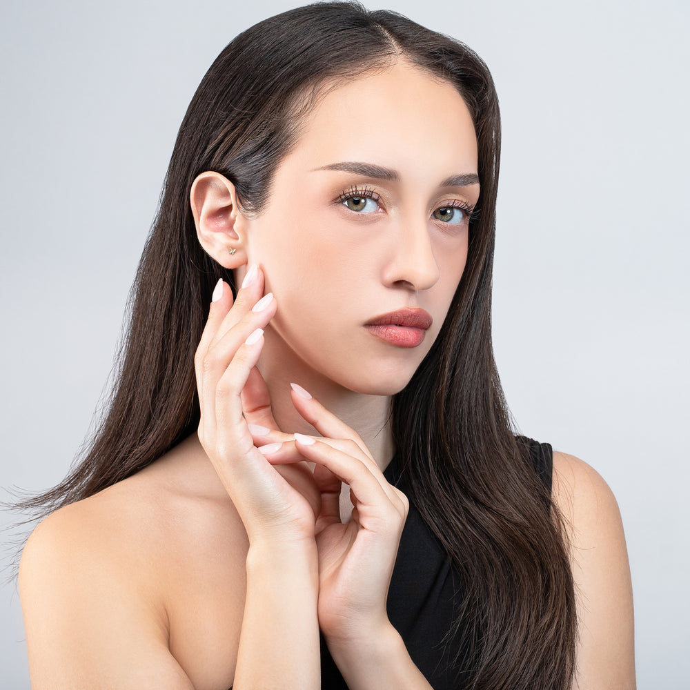 Woman touching her face with a neutral background