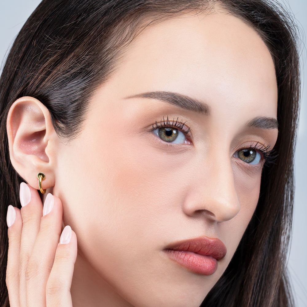 Close-up of a woman wearing an earring with a neutral background