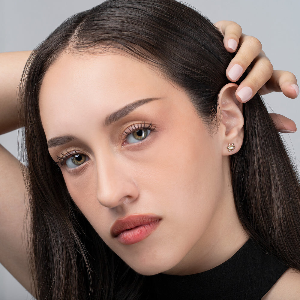 Close-up of a woman with her hand in her hair against a neutral background