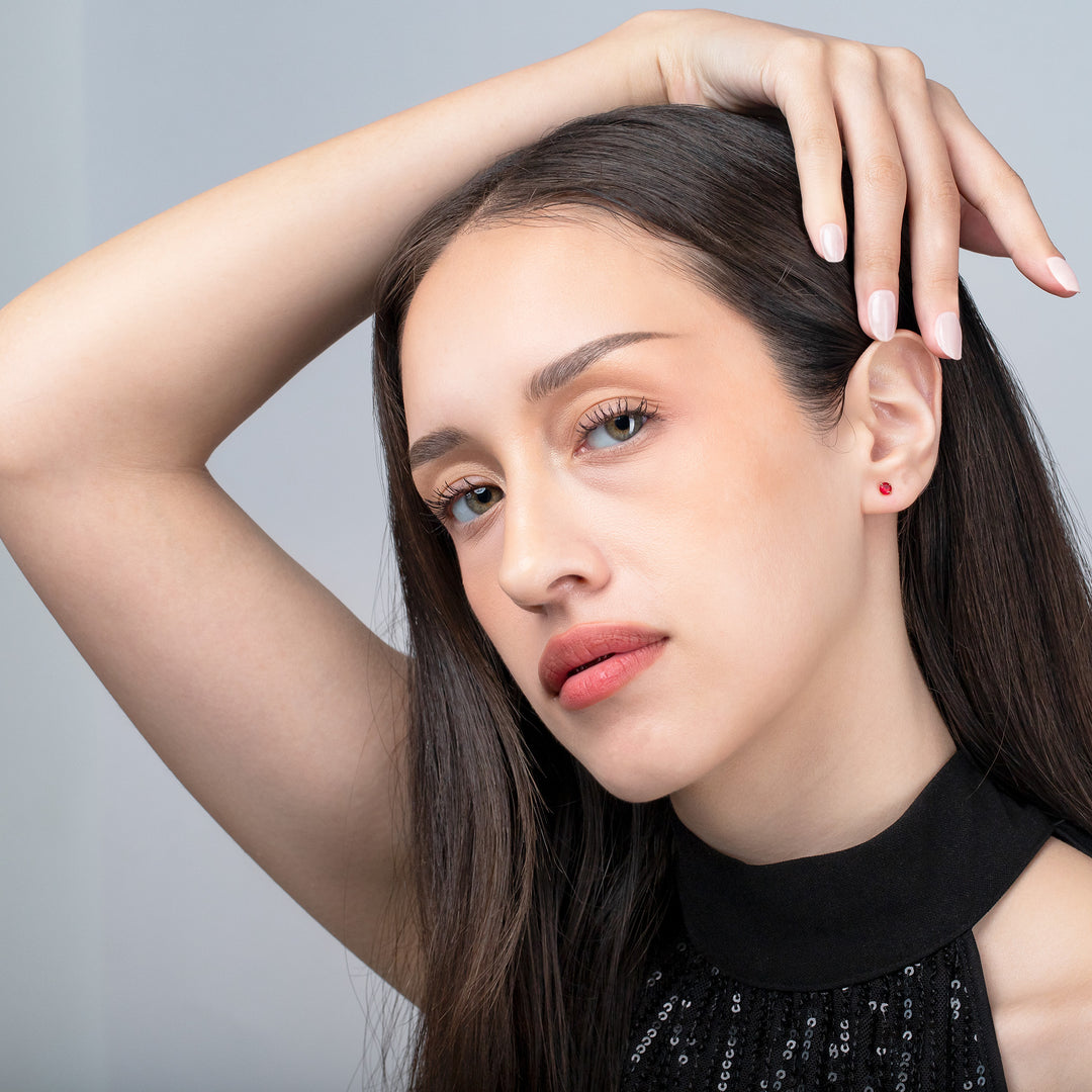 Woman with long dark hair and a black top against a gray background