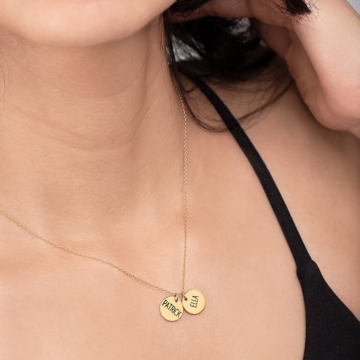 Gold-tone necklace with two engraved round disc pendants worn at the neckline