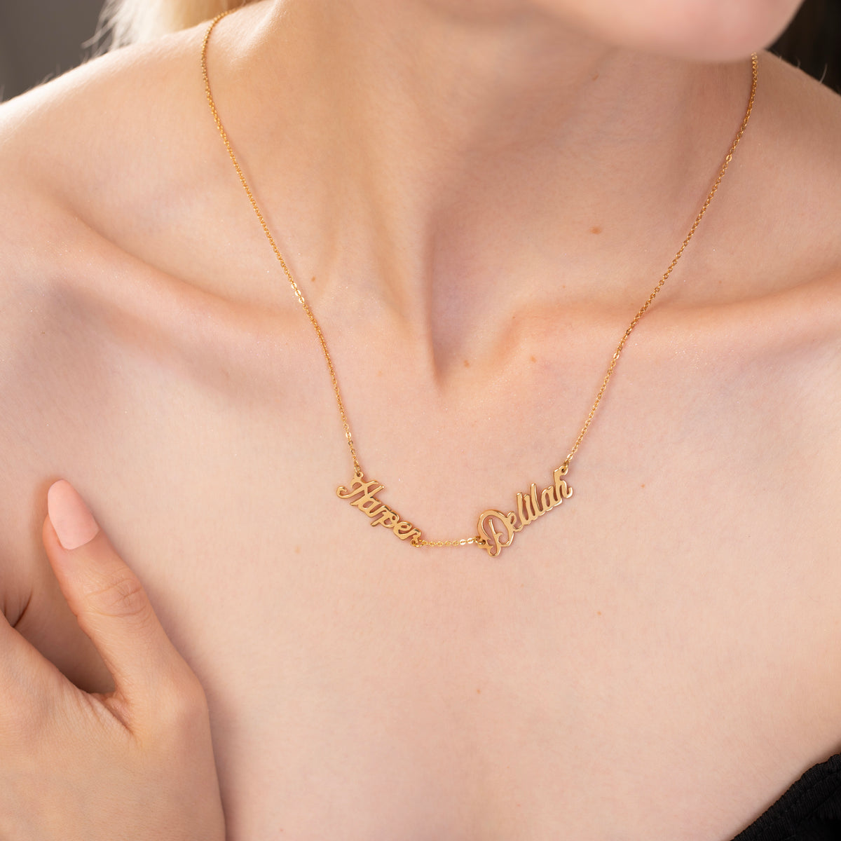 Gold necklace with personalized names on a person's neck
