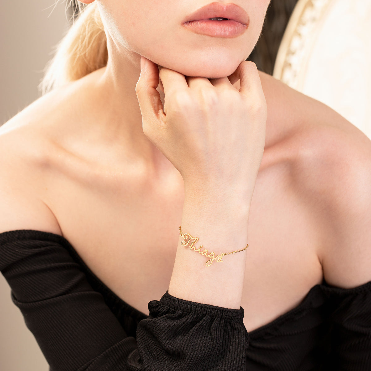 Close-up of a person wearing a gold bracelet on their wrist.