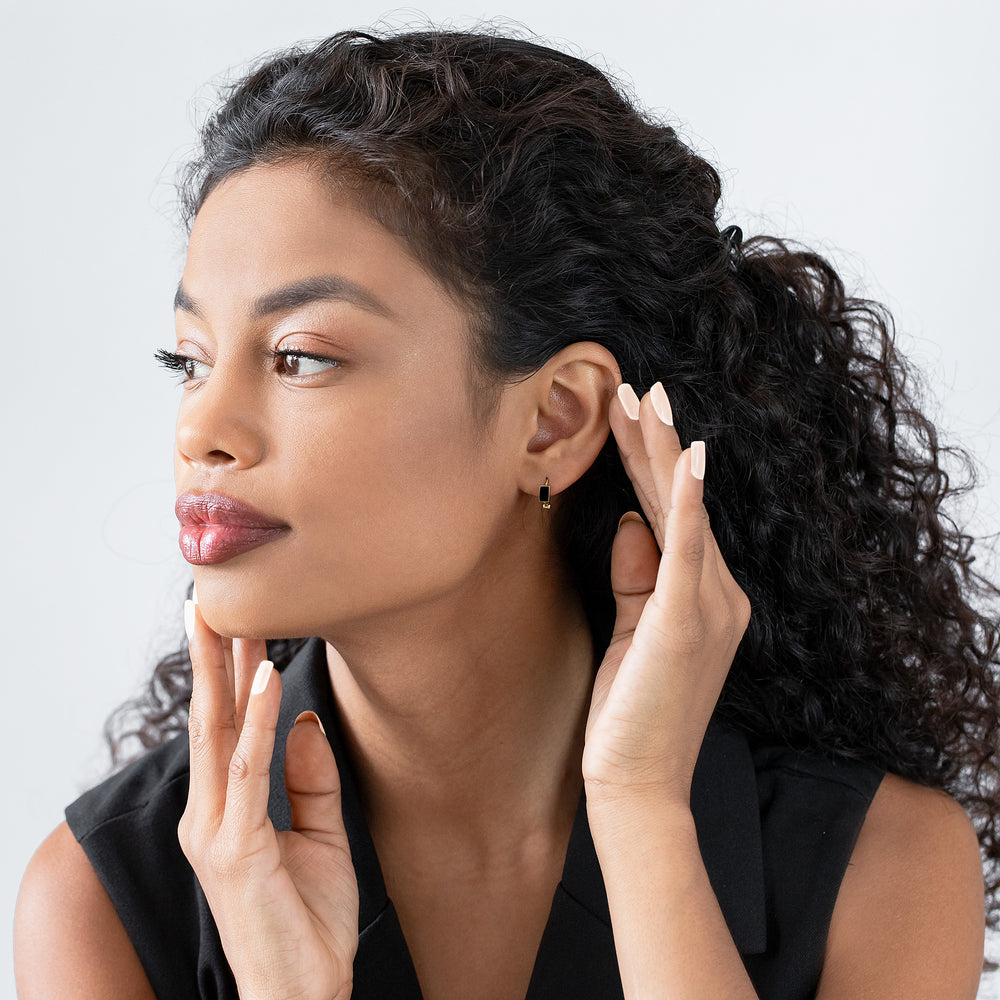 Woman adjusting her hair with a neutral background