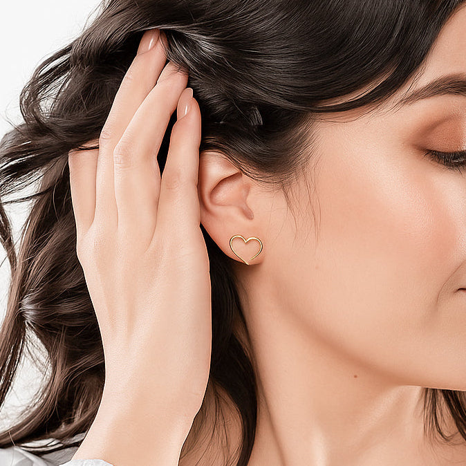 Woman wearing a heart-shaped earring with a neutral background