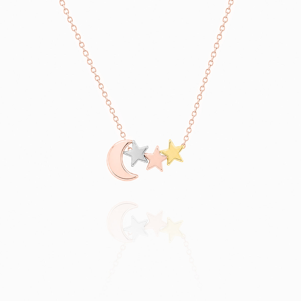 Rose-gold-tone necklace with a crescent moon and three mixed-tone star charms on a white background