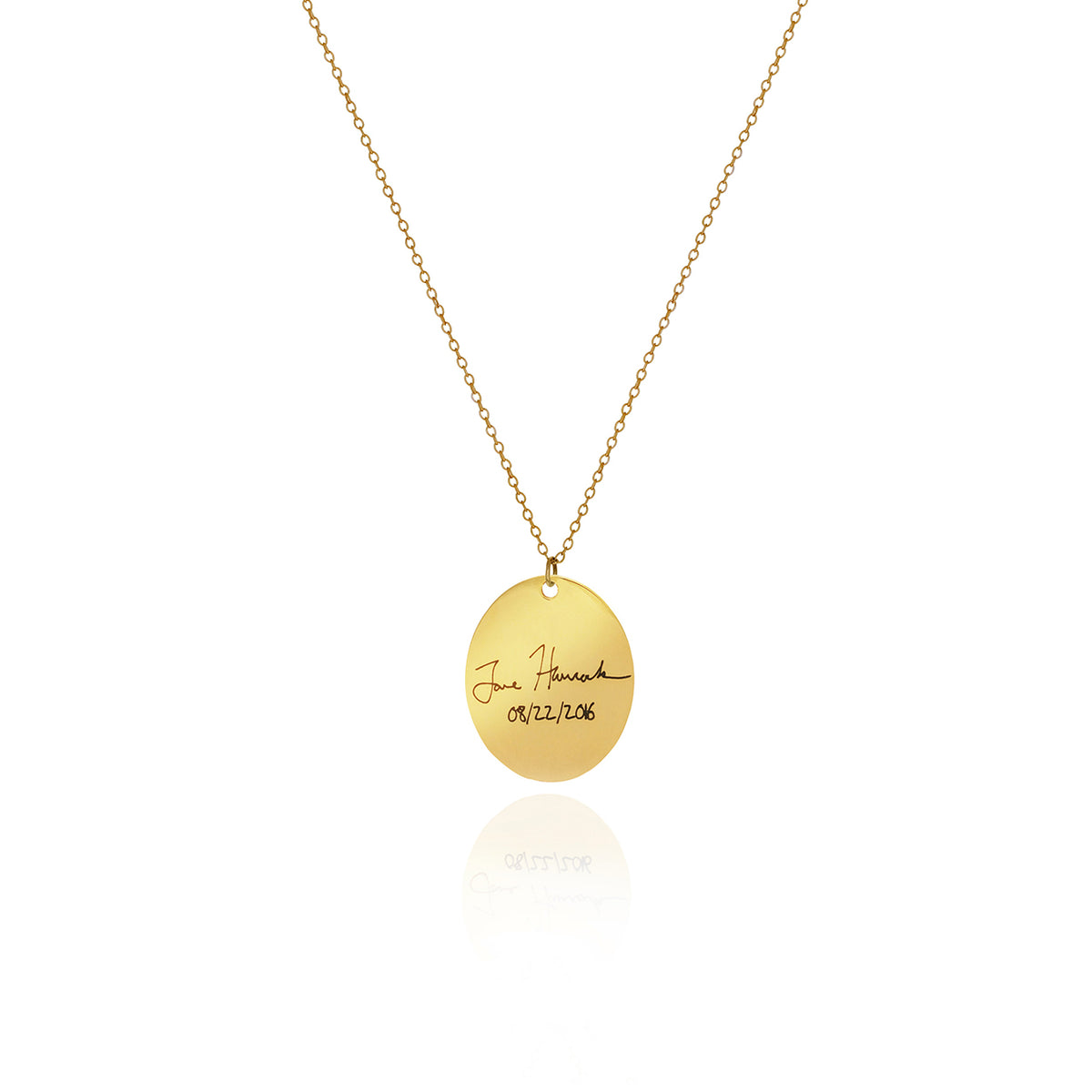 Gold-tone oval necklace with handwritten engraving and a date on a white background