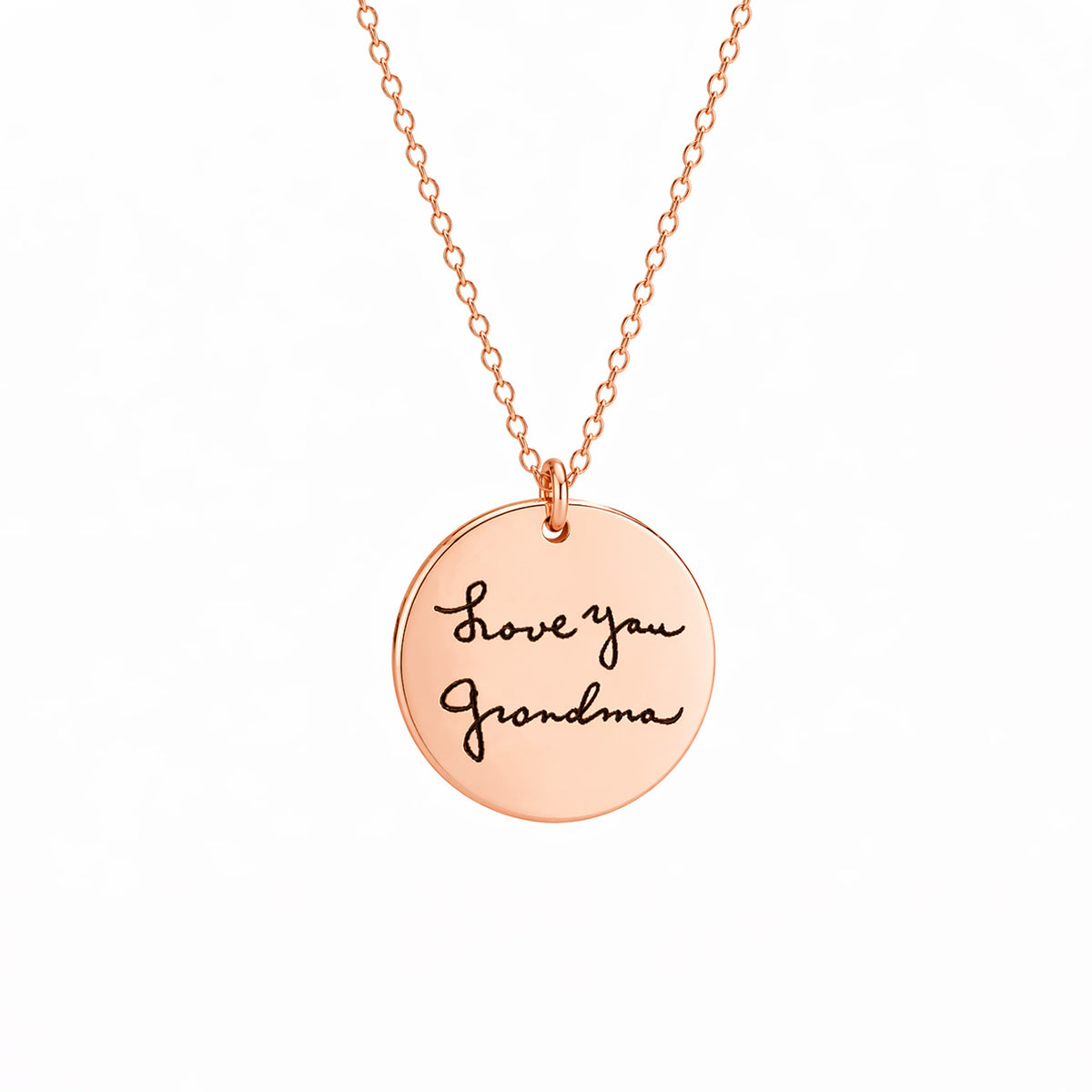 Rose-gold-tone round pendant necklace engraved Love you Grandma in handwritten script on a white background